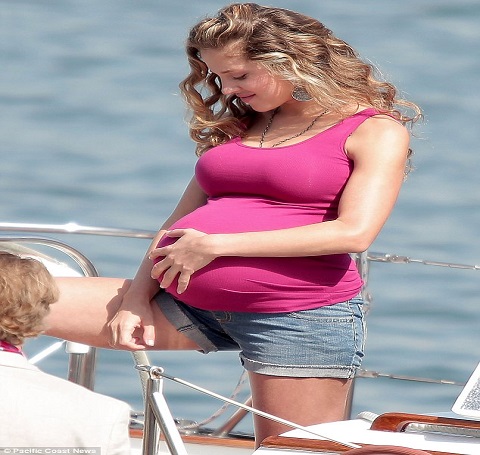 Margarita enceinte se sentant bénie avec son baby bump.