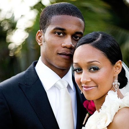 Tia Mowry posing for a picture with her husband on the wedding day