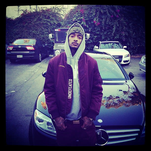 Nipsey Hussle with his luxury car