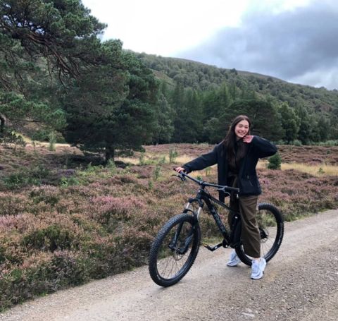 Nittha Jirayungyurn poses a picture while cycling at Scotland in black top and tracks. 