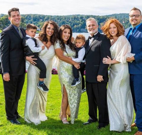 Jaryn Arnold Rothman holds a kid with her family  and lifepartner Noah Rothman on their special wedding day.