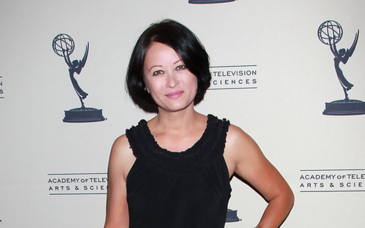 A woman with a bob cut and a black dress at an event.