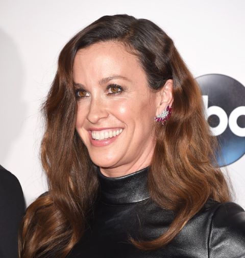 A woman with a brown hair and a leather tp at an event.