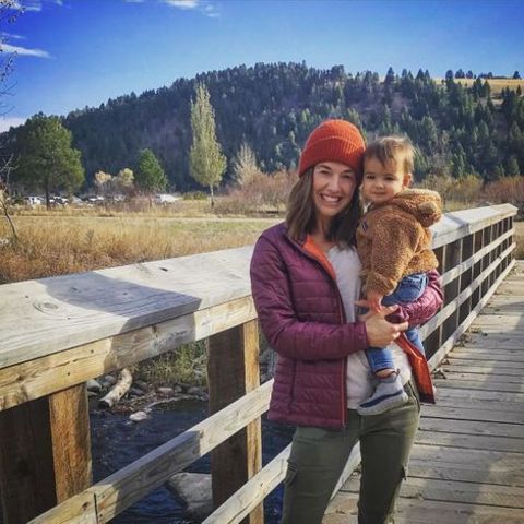 Parvati Shallow giving a pose while holding her daughter.