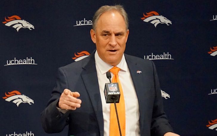 Vic Fangio in a black suit poses during an interview.