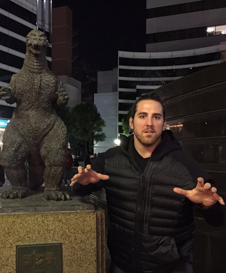 Anthony Castonzo taking a picture in front of a Godzilla statue

