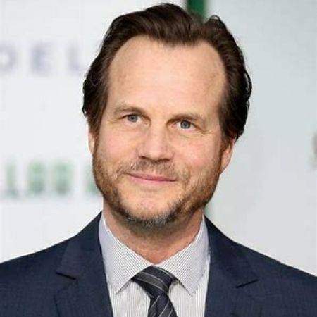 Late Bill Paxton posing for a photo at an event.